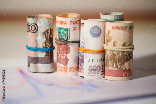 Rubles in a roll on a background of graphs photo
