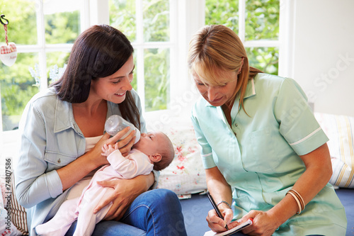 Mother With Baby Meeting With Health Visitor At Home photo