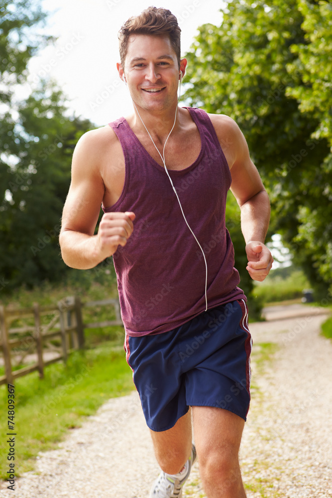Man Running In Countryside Wearing Earphones Man Running In Countryside Wearing Earphones