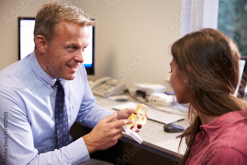 Doctor Showing Female Patient Model Of Human Ear photo