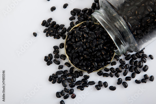 Black beans in a jar on white  table with lid off