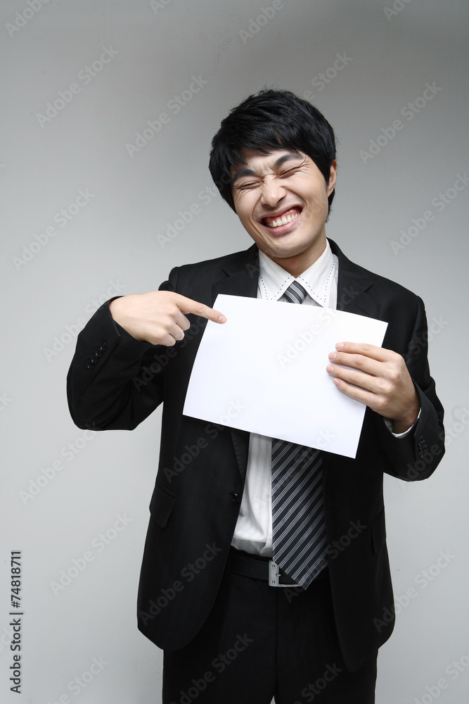 흰 배경 스튜디오에서 검은 정장을 입고 미소를 지으며 제스처를 취하는 젊은 남성 