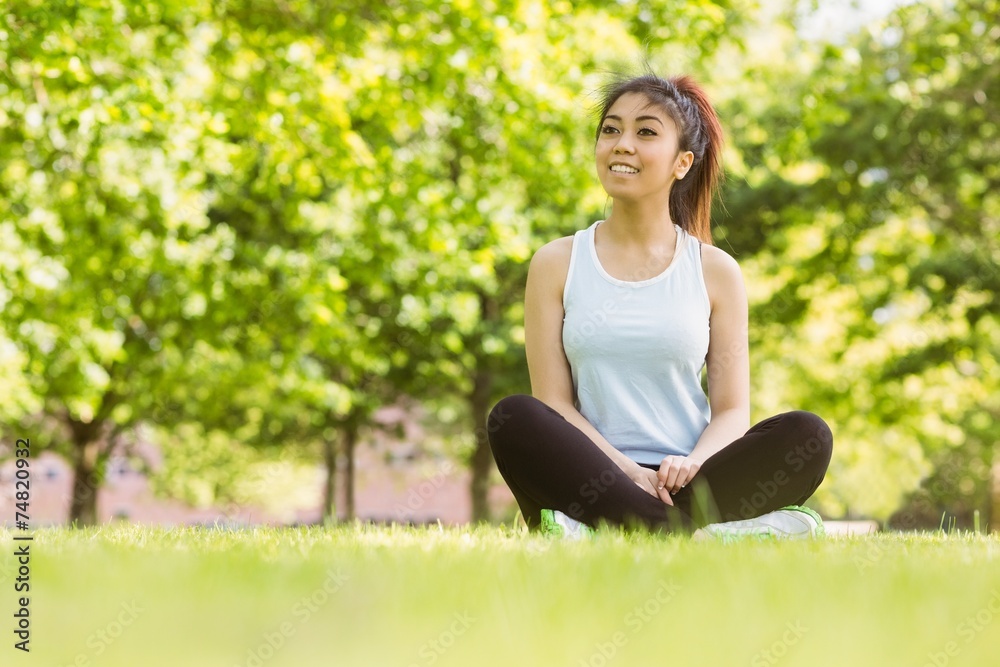 Healthy woman sitting on grass in park Healthy woman sitting on grass in park