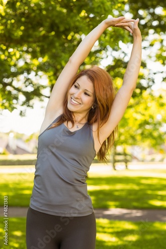 Pretty redhead stretching in the park