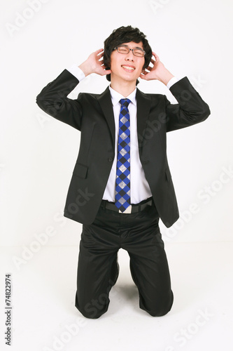 무릎 꿇고 앉아 있는 검은 정장의 비즈니스맨