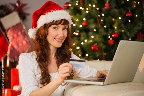 Smiling redhead shopping online with laptop © WavebreakmediaMicro