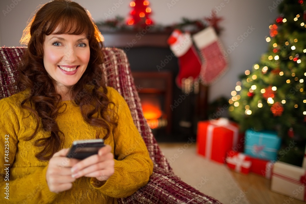 Happy redhead using mobile at christmas Happy redhead using mobile at christmas