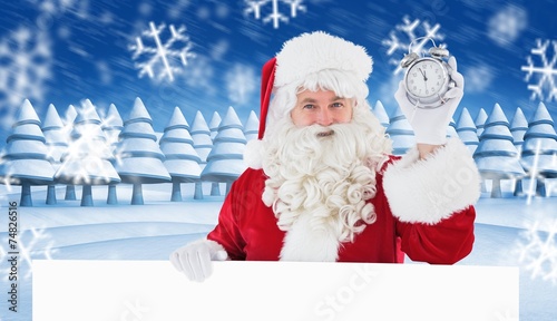 Composite image of santa claus holding alarm clock and sign © WavebreakmediaMicro