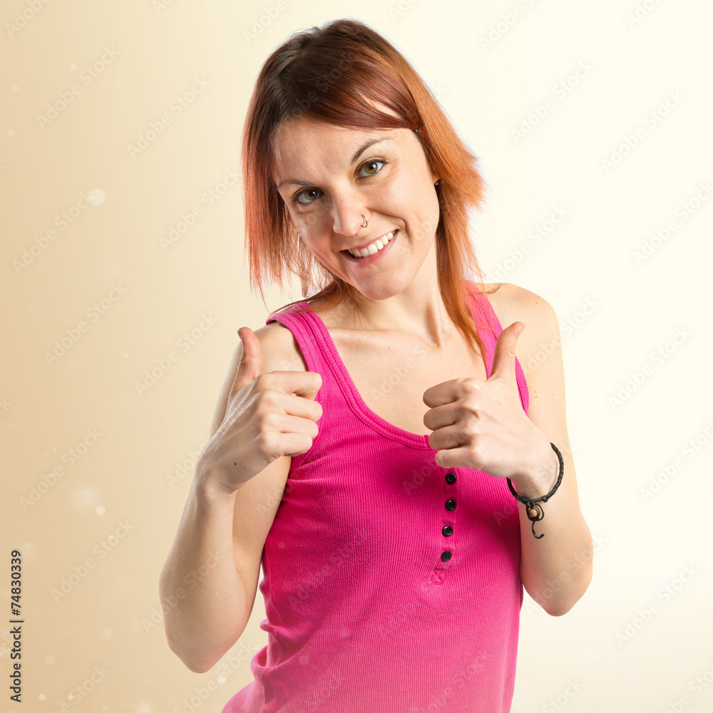 Pretty young girl with thumbs up over white background