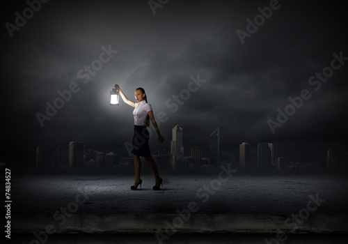 Businesswoman with lantern © Sergey Nivens