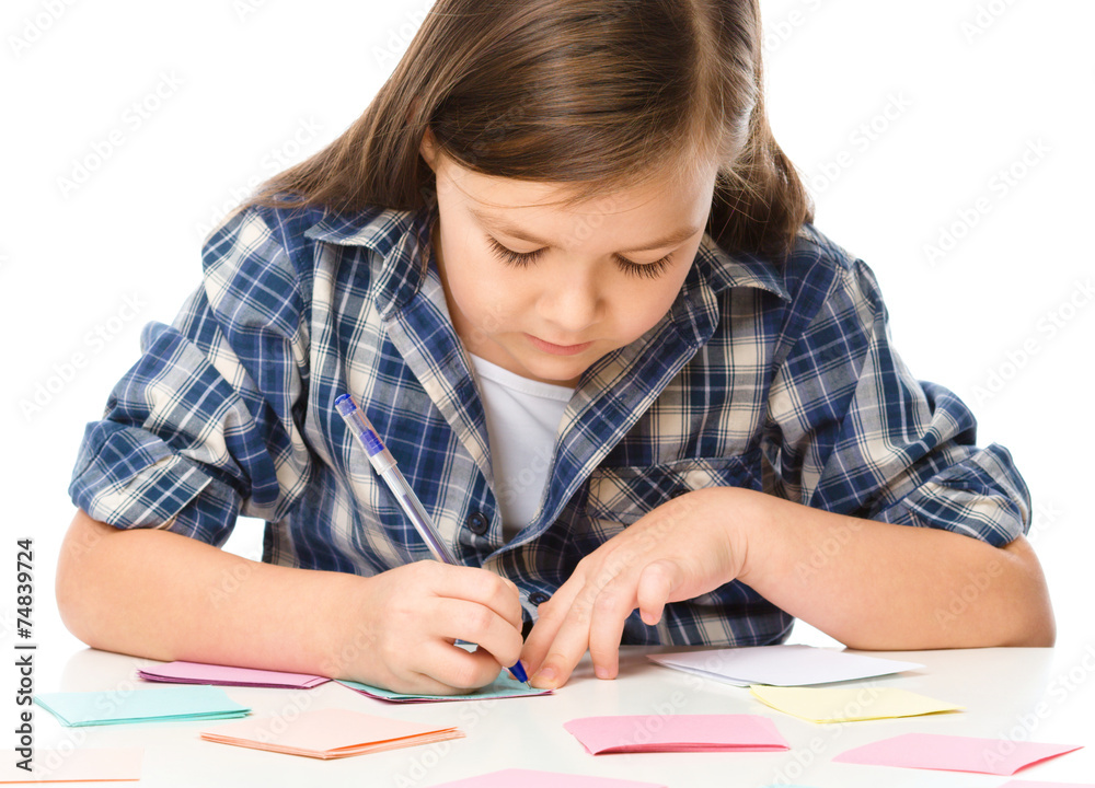 Girl is writing on color stickers using pen Girl is writing on color stickers using pen