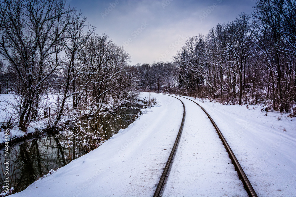 Snow covered railroad tracks and creek in rural Carroll County,