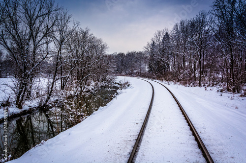 Snow covered railroad tracks and creek in rural Carroll County, © jonbilous