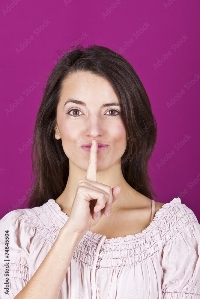 Naklejka premium Portrait of a confident young woman with a finger on her lips