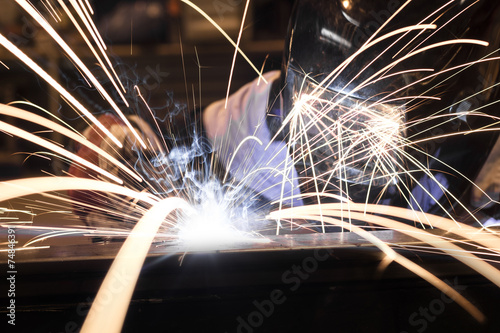 Employee welding steel using MIG/MAG welder. photo