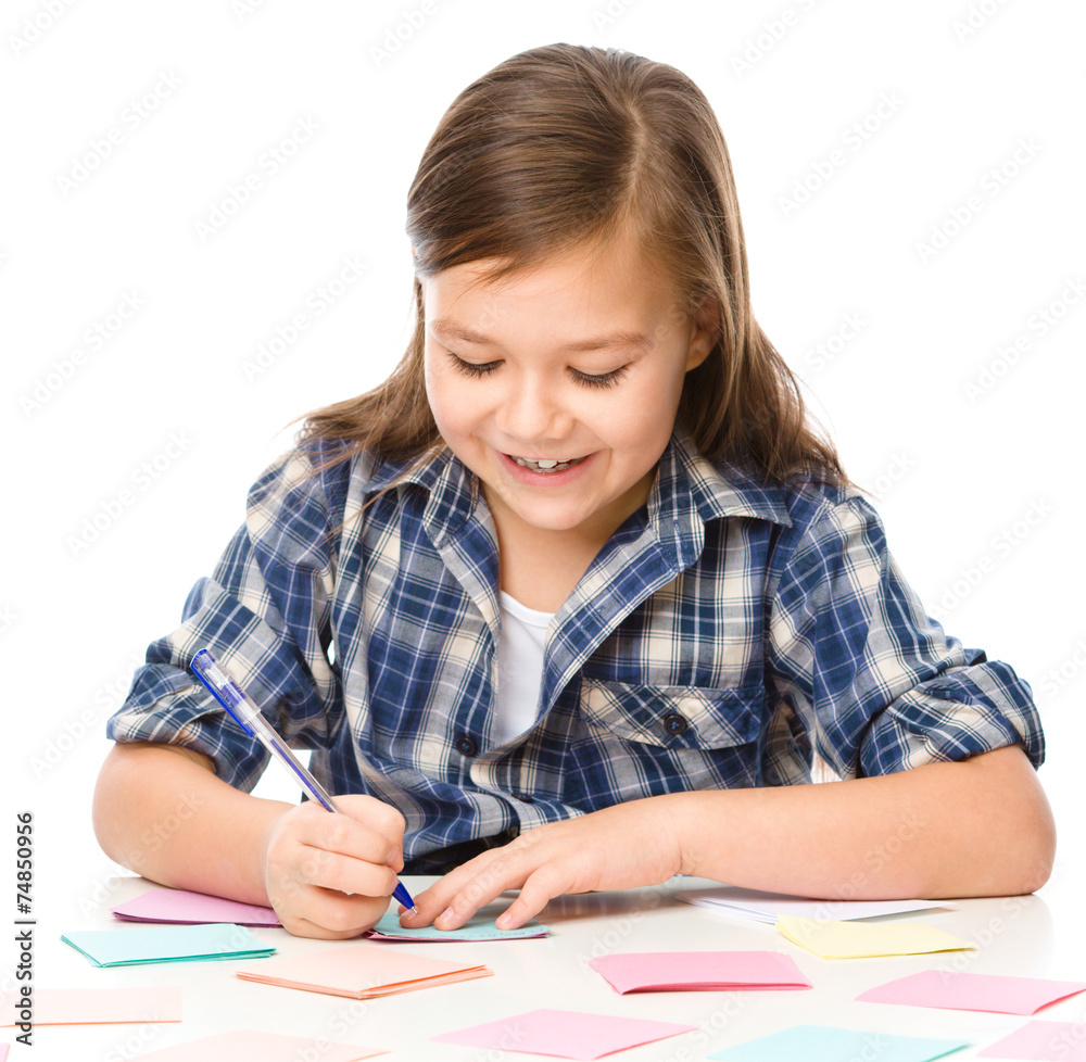 Girl is writing on color stickers using pen Girl is writing on color stickers using pen