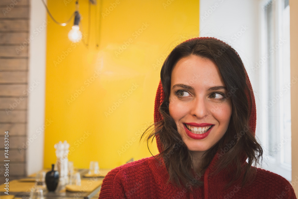 Portrait of a beautiful young brunette sitting at the table Portrait of a beautiful young brunette sitting at the table