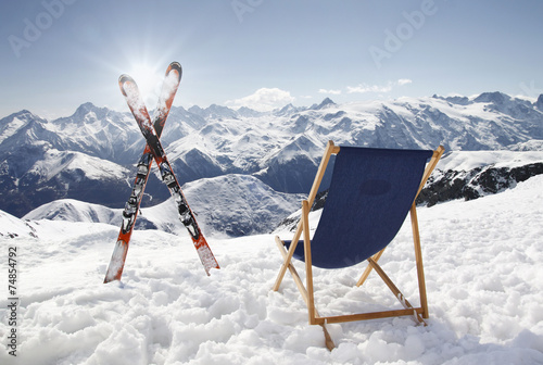 Cross ski and Empty sun-lounger at mountains