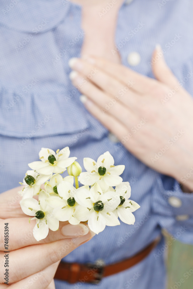 Woman holding bouquet of tiny white flowers (ornithogalum arabic Woman holding bouquet of tiny white flowers (ornithogalum arabic