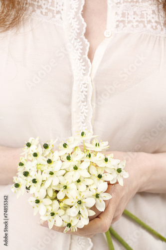 Woman holding bouquet of tiny white flowers (ornithogalum arabic