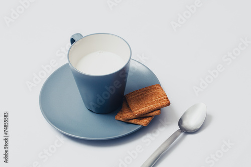 Cup of mil with biscuits. White background.