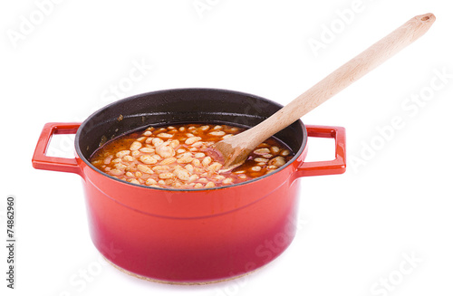 Bean cooked in cast iron cooking pot with wooden spoon