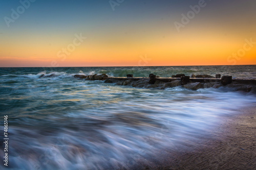 Waves and a jetty at sunset in the Atlantic Ocean at Edisto Beac