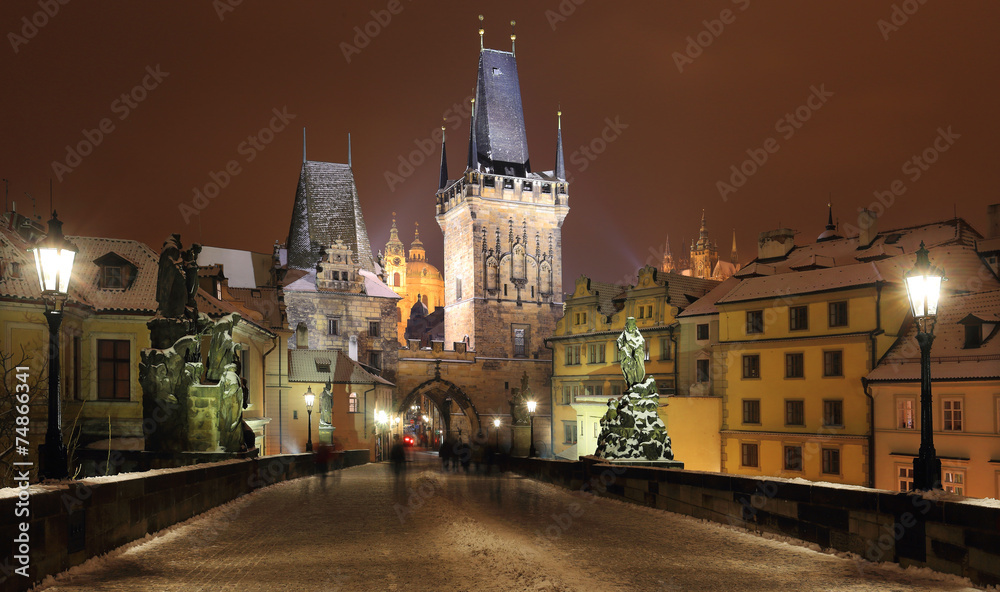 Fototapeta premium Night snowy Prague St. Nicholas' Cathedral from Charles Bridge
