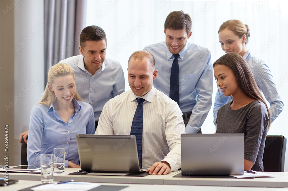 smiling businesspeople with laptops in office smiling businesspeople with laptops in office