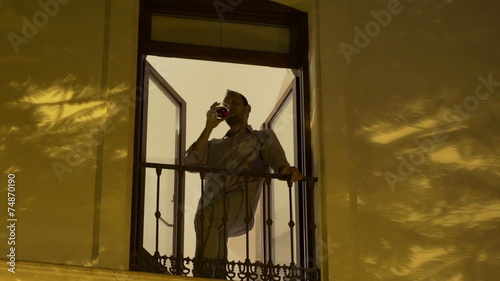 Wallpaper Mural Happy handsome man drinking wine on balcony at night  Torontodigital.ca