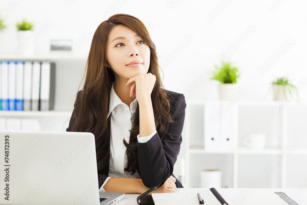 smiling young business woman thinking in the office smiling young business woman thinking in the office