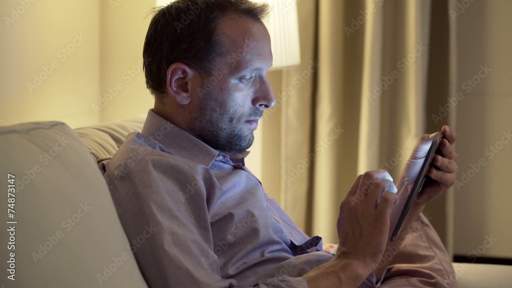 man with tablet computer sitting on sofa at home man with tablet computer sitting on sofa at home