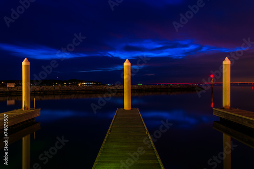 Docks and pier posts in a marina at night, in Kent Island, Maryl photo