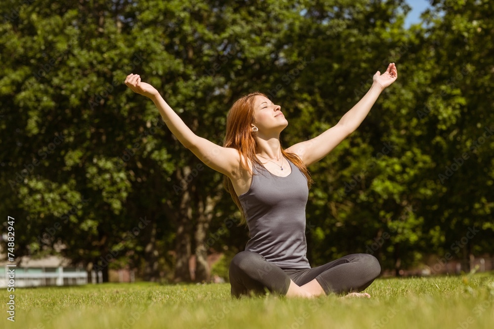 Portrait of a pretty redhead in lotus pose