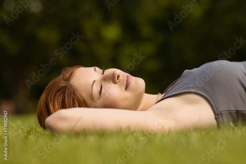 Pretty redhead lying with her eyes closed