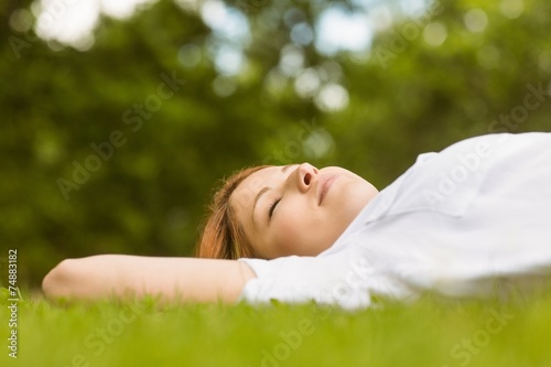 Pretty redhead lying with her eyes closed