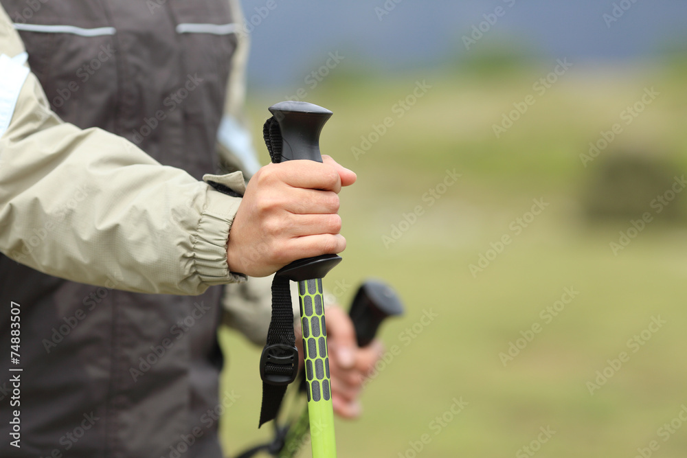 Hiker hands holding a hiking pole while walking