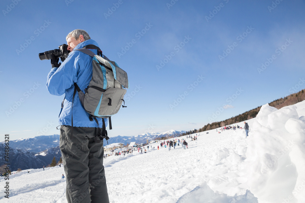 Nature photographer taking photos in the snowy mountain