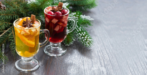 spicy Christmas drinks in glasses on a wooden background