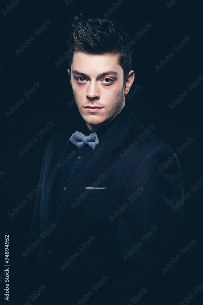 Obraz premium Retro fashion man with blue shirt, jacket, jeans and bow tie. Sh