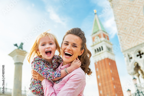 Portrait of happy mother and baby against campanile di san marco
