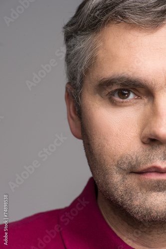 half face of adult man on grey background.