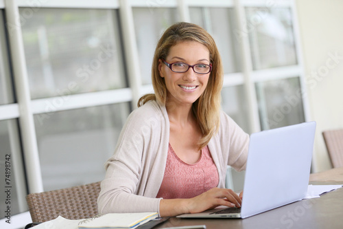 Free Download Middle-aged woman working from home on laptop - GFXLoad
