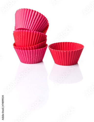 Red silicone cupcake baking cups over white background 