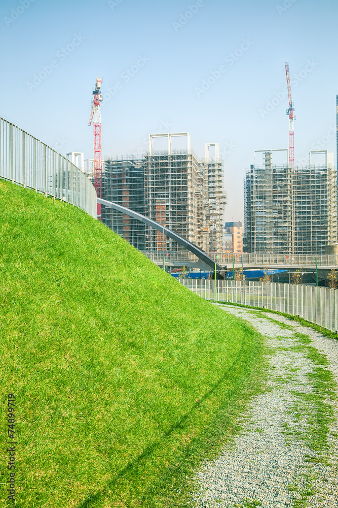 Walking path with green grass and construction site