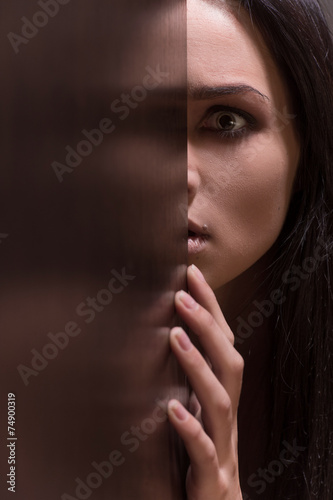 Beautiful young brunette woman looking scared.
