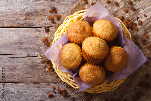 Orange muffins in a basket top view horizontal