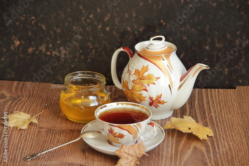 Still-life with a cup of tea, honey and autumn leaves