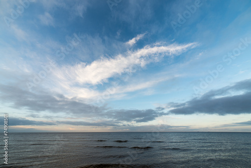 baltic beach in fall with clouds and waves towards deserted dune