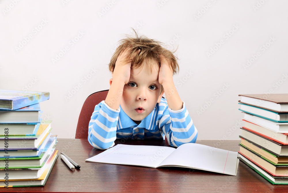 little tired boy sitting at a desk little tired boy sitting at a desk